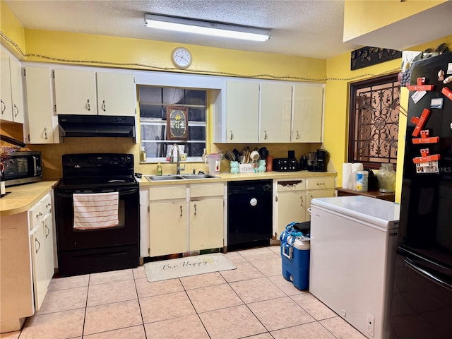 kitchen with light tile patterned floors, sink, a textured ceiling, and black appliances