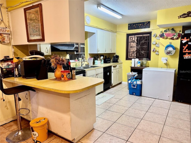 kitchen with refrigerator, kitchen peninsula, sink, dishwasher, and a kitchen breakfast bar