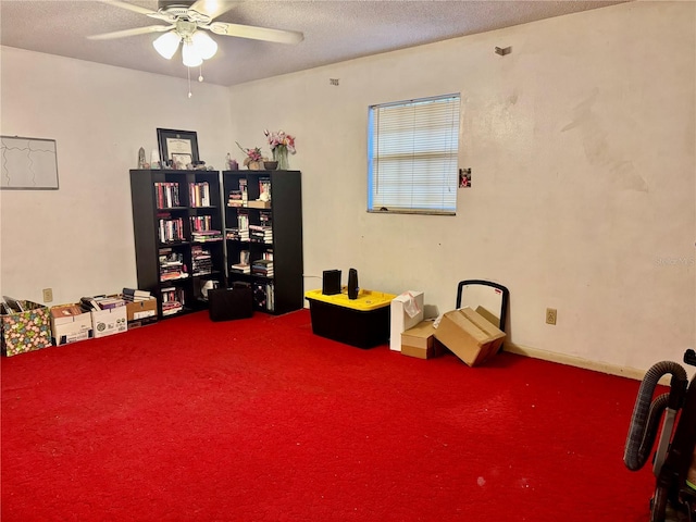 misc room featuring ceiling fan, carpet, and a textured ceiling