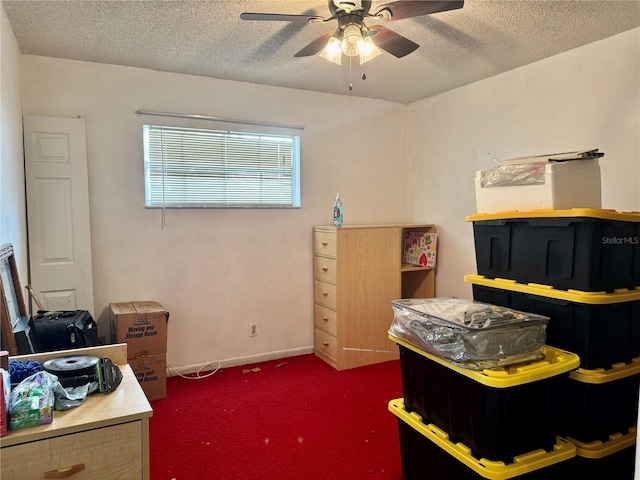 interior space with ceiling fan, dark colored carpet, and a textured ceiling