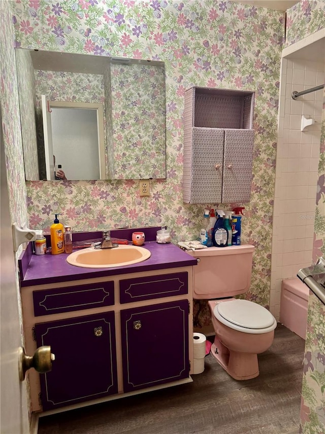 full bathroom with hardwood / wood-style flooring, toilet, vanity, and tiled shower / bath combo