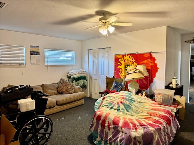 carpeted bedroom featuring ceiling fan and a textured ceiling