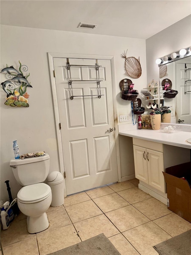 bathroom featuring toilet, vanity, and tile patterned flooring