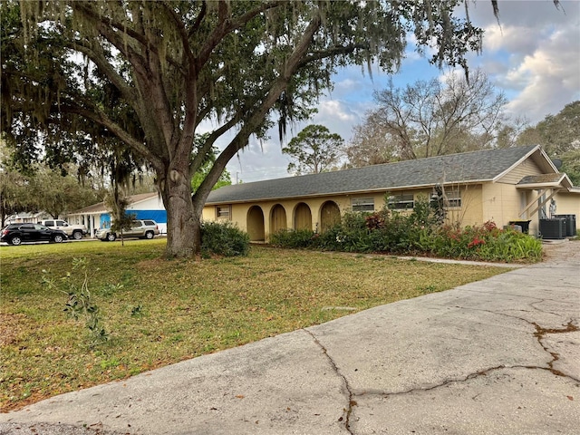 single story home featuring a front lawn and cooling unit