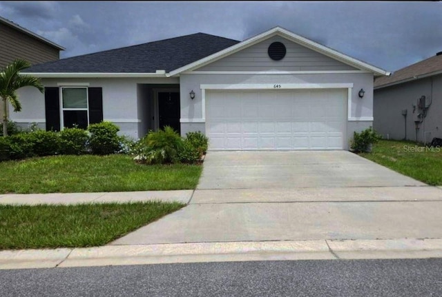 ranch-style home with stucco siding, a shingled roof, an attached garage, driveway, and a front lawn