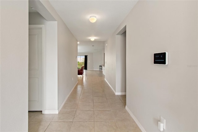 hall with light tile patterned floors and baseboards