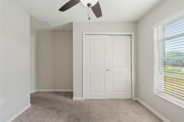 unfurnished bedroom featuring baseboards, a closet, and light colored carpet