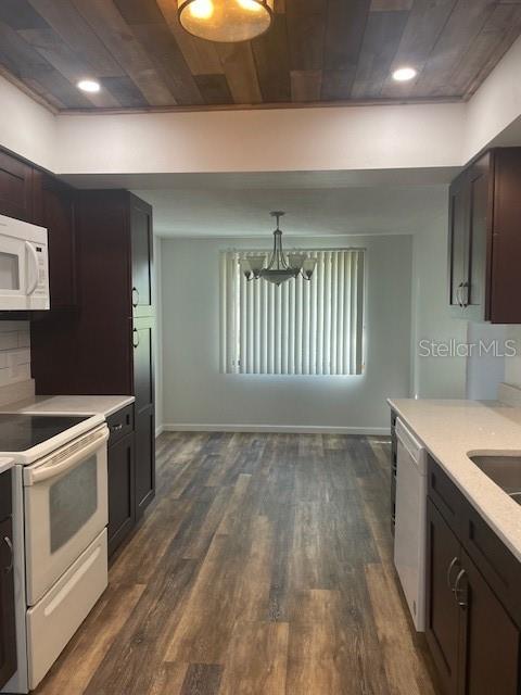 kitchen featuring light countertops, white appliances, dark wood finished floors, and dark brown cabinetry