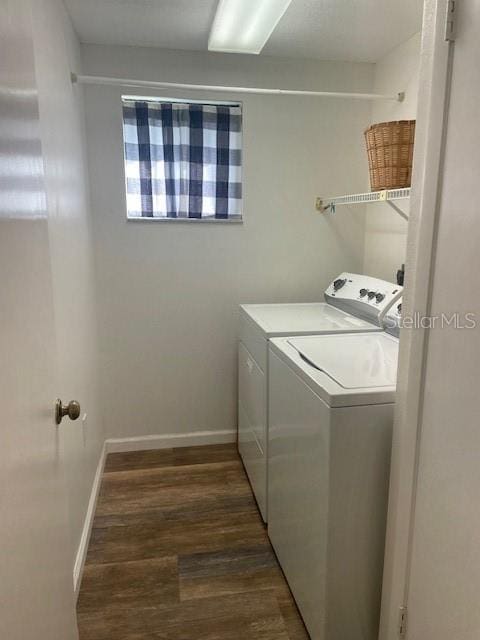 laundry area with laundry area, baseboards, washer and clothes dryer, and dark wood-type flooring