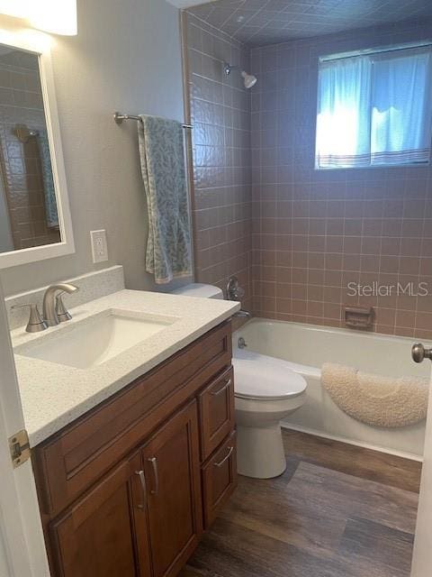 full bathroom featuring toilet, vanity, shower / bathtub combination, and wood finished floors