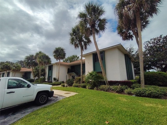 view of front of property featuring stucco siding and a front yard