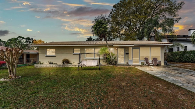 back house at dusk with a yard