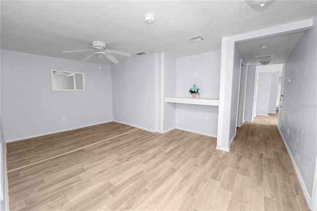 empty room featuring light hardwood / wood-style flooring, ceiling fan, and a textured ceiling