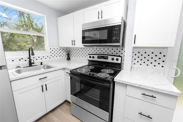 kitchen with white cabinets, appliances with stainless steel finishes, sink, and tasteful backsplash