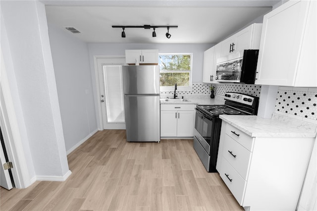 kitchen featuring sink, appliances with stainless steel finishes, and white cabinets