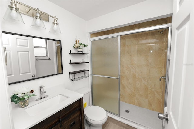 bathroom with toilet, a shower with door, and vanity