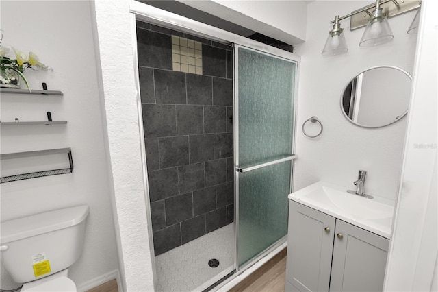 bathroom featuring hardwood / wood-style flooring, vanity, toilet, and walk in shower