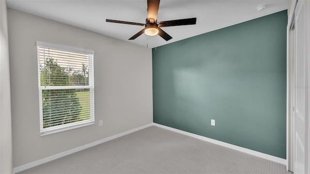 carpeted spare room with ceiling fan