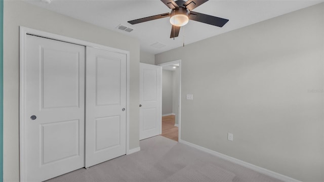 unfurnished bedroom featuring a closet, ceiling fan, and light colored carpet