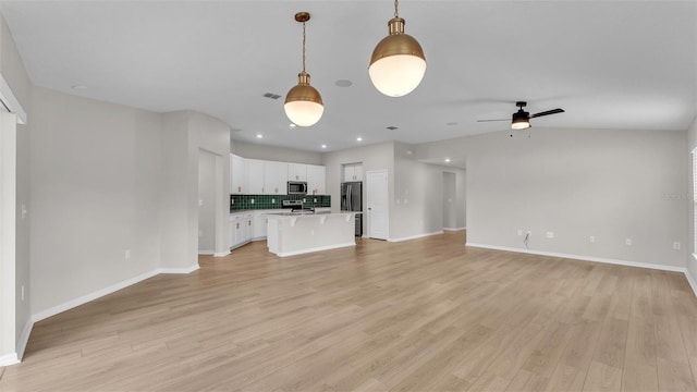 unfurnished living room with ceiling fan, light hardwood / wood-style floors, and lofted ceiling