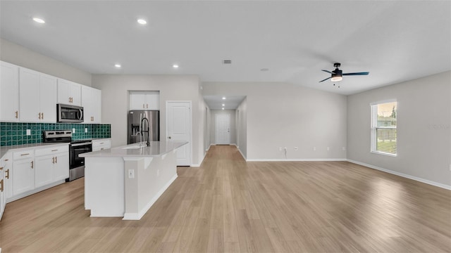 kitchen featuring an island with sink, light wood-type flooring, white cabinetry, and stainless steel appliances