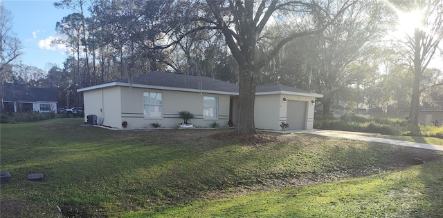 exterior space featuring an attached garage, central air condition unit, concrete driveway, stucco siding, and a front yard