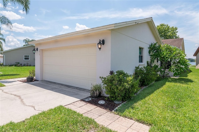 3976 Cypress Lndg W, Winter Haven, FL 33884 - view of home's exterior with stucco siding, driveway, a lawn, and an attached garage