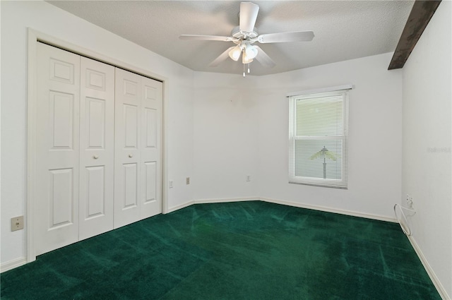 3976 Cypress Lndg W, Winter Haven, FL 33884 - unfurnished bedroom with dark carpet, a closet, a ceiling fan, and a textured ceiling