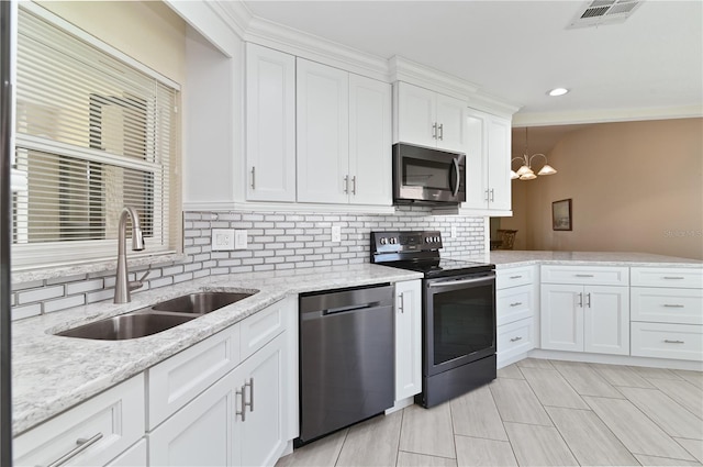 3976 Cypress Lndg W, Winter Haven, FL 33884 - kitchen with stainless steel appliances, white cabinetry, backsplash, light stone countertops, and a chandelier