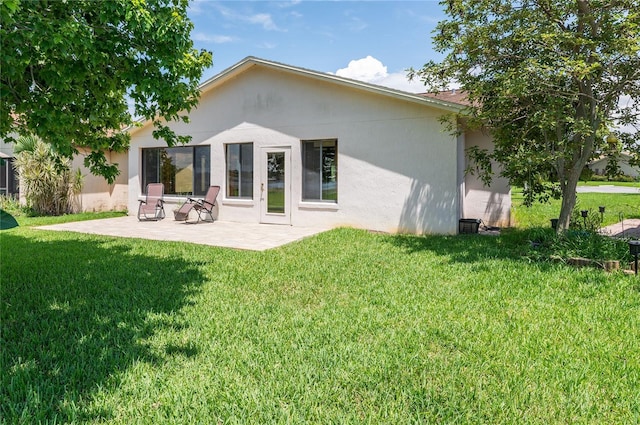 3976 Cypress Lndg W, Winter Haven, FL 33884 - back of house featuring stucco siding, a lawn, and a patio