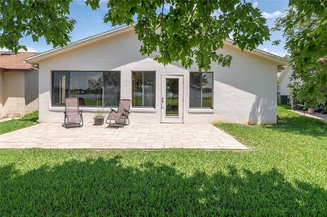 3976 Cypress Lndg W, Winter Haven, FL 33884 - rear view of property featuring a patio, stucco siding, and a lawn