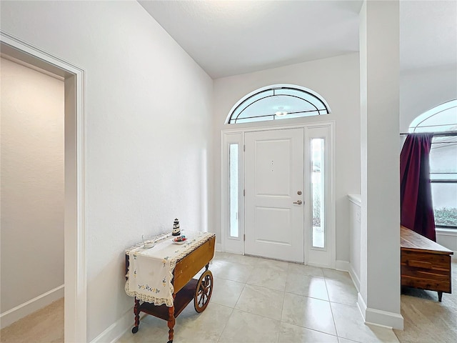 foyer with plenty of natural light, baseboards, and light tile patterned floors