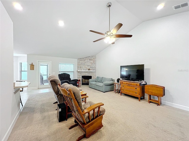 living area with ceiling fan, a stone fireplace, visible vents, and light colored carpet