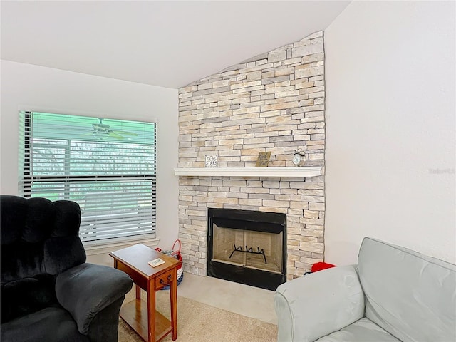 living room with vaulted ceiling and a stone fireplace