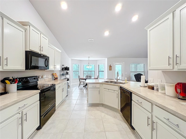 kitchen featuring light tile patterned flooring, a sink, hanging light fixtures, light countertops, and black appliances