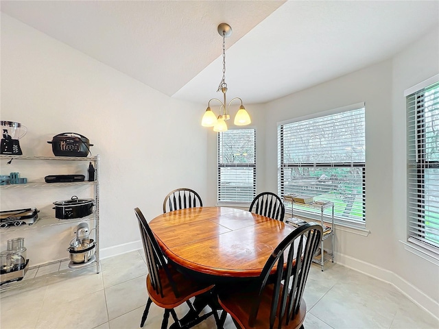 dining space with baseboards, light tile patterned flooring, and a notable chandelier