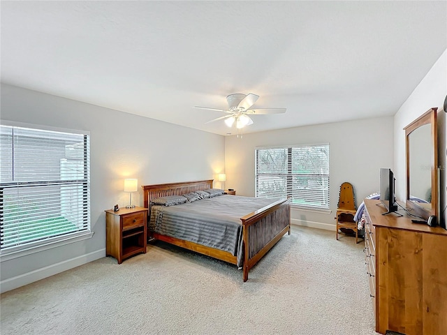 bedroom featuring baseboards, a ceiling fan, and light colored carpet