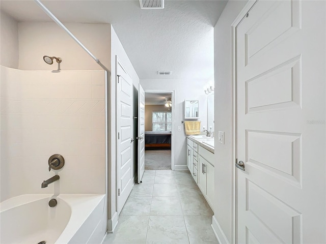 ensuite bathroom featuring visible vents, connected bathroom,  shower combination, a textured ceiling, and vanity