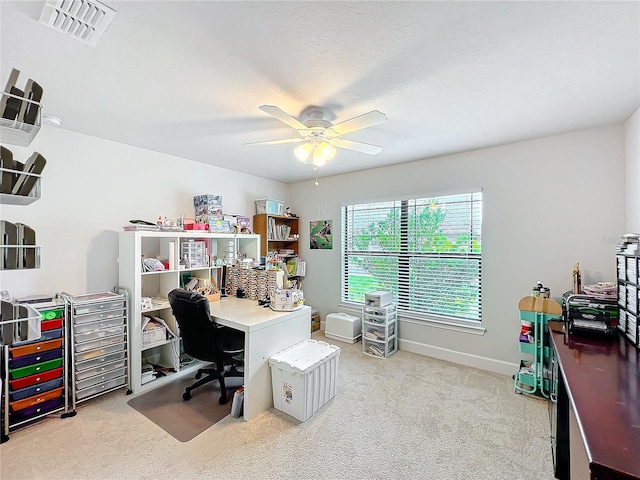 home office featuring visible vents, baseboards, light colored carpet, ceiling fan, and a textured ceiling