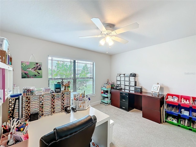 office space with a ceiling fan and light colored carpet