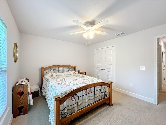 carpeted bedroom featuring a ceiling fan, a closet, visible vents, and baseboards