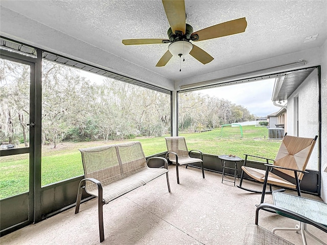 sunroom / solarium featuring a ceiling fan