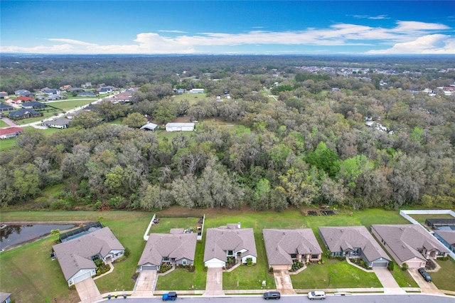 birds eye view of property featuring a residential view, a water view, and a wooded view