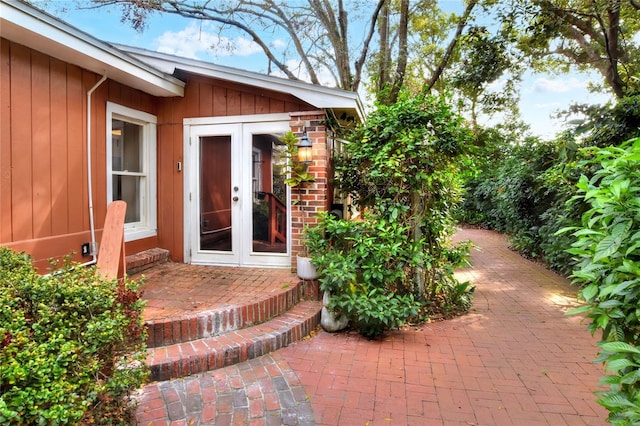 view of exterior entry featuring a patio area, brick siding, and french doors