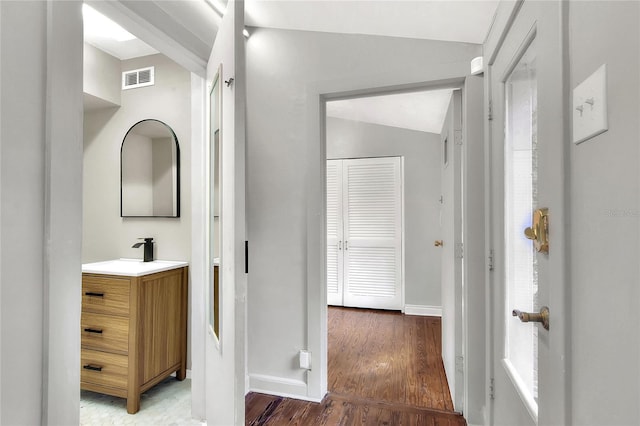 bathroom with visible vents, vanity, baseboards, and wood finished floors