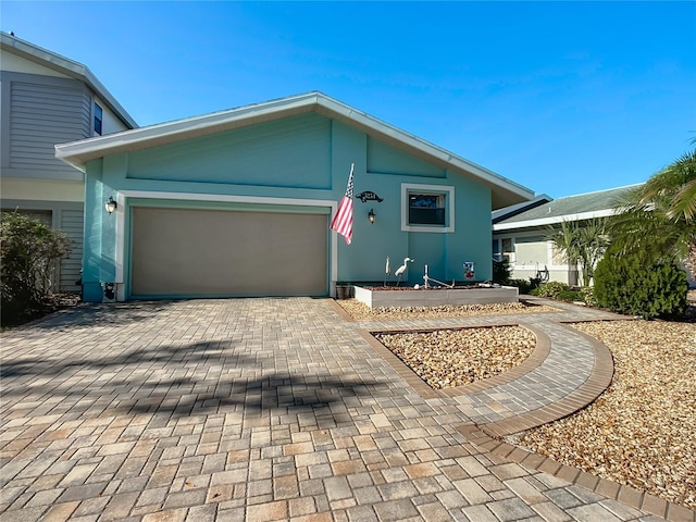 view of front of home with an attached garage and decorative driveway