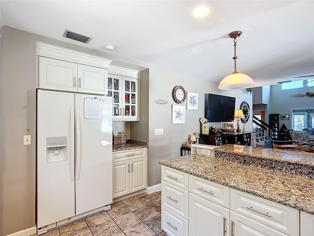 kitchen with visible vents, white cabinetry, open floor plan, white fridge with ice dispenser, and glass insert cabinets