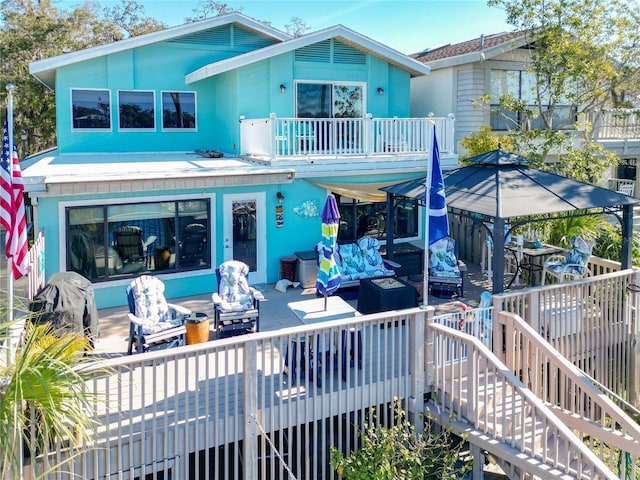 back of property featuring a balcony, stairway, and a wooden deck