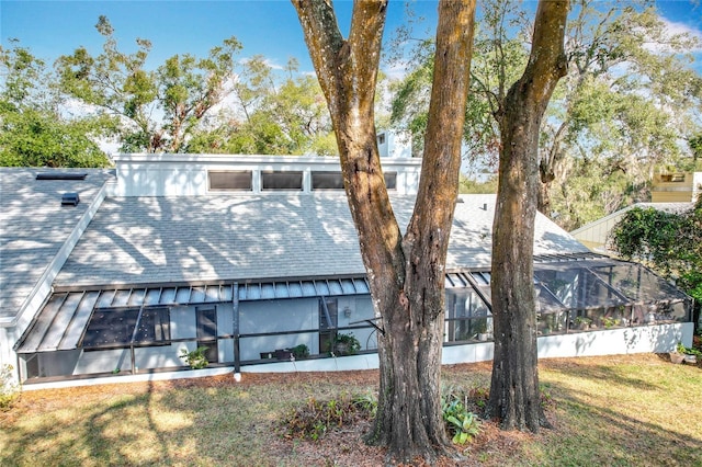 view of side of property with a lanai and a yard