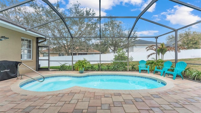 view of swimming pool with glass enclosure and a patio area